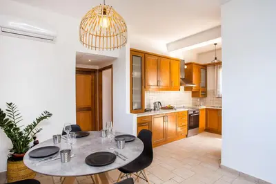 a dining room with a table and chairs and a kitchen at Apartment Ivy Kallithea in Rhodes Town