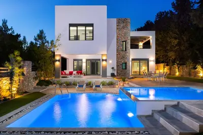 a villa with a swimming pool in front of a house at Villa Summer Light in Kiotari