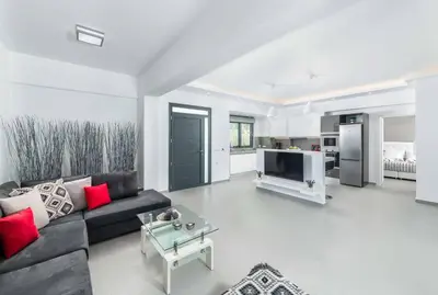 a living room with a black couch and a tv at Villa Summer Light in Kiotari
