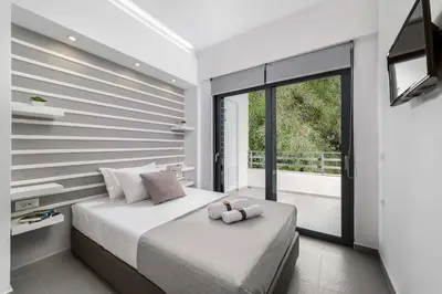 a bedroom with a large bed and a balcony at Villa Summer Light in Kiotari