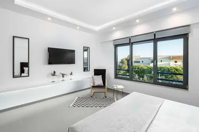 a white room with a bed and a tv at Villa Summer Light in Kiotari