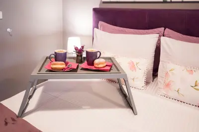 a tray with two drinks and two donuts on a bed at Lila Studio in Kalathos