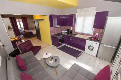 a living room with a couch and a kitchen at Lila Studio in Kalathos