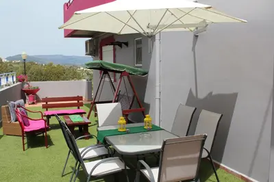 a patio with a table and chairs and an umbrella at Lila Studio in Kalathos