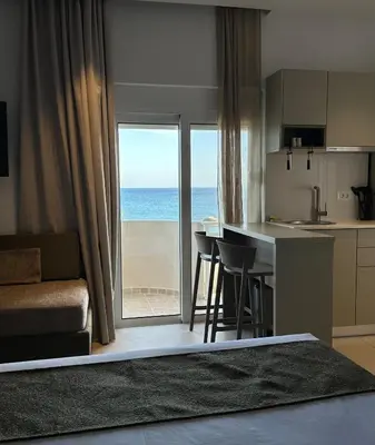 a living room with a kitchen and a view of the ocean at Stegna Sea & Sun in Archangelos