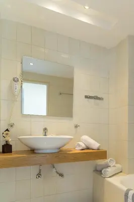 a bathroom with a white sink and a mirror at City Center Hotel in Rhodes Town