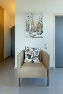a chair in a room with a painting on the wall at City Center Hotel in Rhodes Town