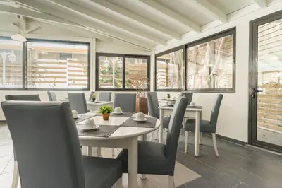 a dining room with tables and chairs and windows at City Center Hotel in Rhodes Town