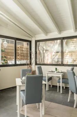 a dining room with tables and chairs and windows at City Center Hotel in Rhodes Town
