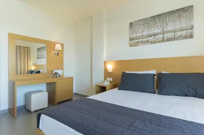 a hotel room with a large bed and a desk at City Center Hotel in Rhodes Town