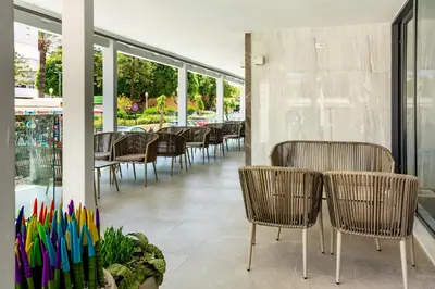 a row of chairs and tables in a restaurant with windows at Rhodos Horizon City-Adults Only in Rhodes Town