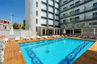 a swimming pool with chairs and a building at Rhodos Horizon City-Adults Only in Rhodes Town