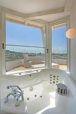 a bathroom with a bath tub with a large window at Rhodos Horizon City-Adults Only in Rhodes Town