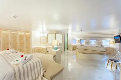 a white room with two beds and a tv at Rhodos Horizon City-Adults Only in Rhodes Town