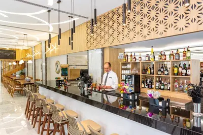a chef standing behind the bar of a restaurant at Rhodos Horizon City-Adults Only in Rhodes Town