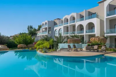 a building with a swimming pool in front of it at Lindos Breeze Beach Hotel in Kiotari