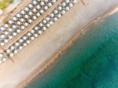 an aerial view of a beach with a bunch of umbrellas at Lindos Breeze Beach Hotel in Kiotari