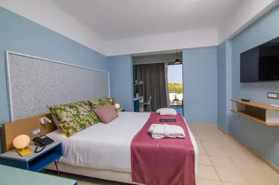 a hotel room with a bed with towels on it at Lindos Breeze Beach Hotel in Kiotari