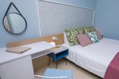 a bedroom with a bed with a desk and a mirror at Lindos Breeze Beach Hotel in Kiotari