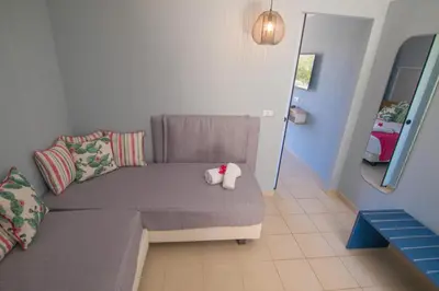 a couch with a stuffed animal on it in a room at Lindos Breeze Beach Hotel in Kiotari