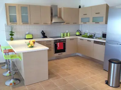 a kitchen with wooden cabinets and a white refrigerator at Villa Anna in Pefki Rhodes