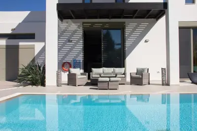 a house with a swimming pool next to a house at Filerimos Oasis Luxury Villa in Ialyssos