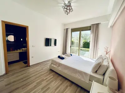 a bedroom with a bed and a large window at Filerimos Oasis Luxury Villa in Ialyssos