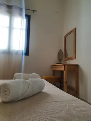 a bedroom with a bed with a mirror and a dresser at Irene Family Apartment in Symi