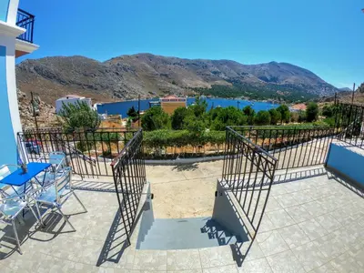 a patio with a view of the water and mountains at Irene Family Apartment in Symi
