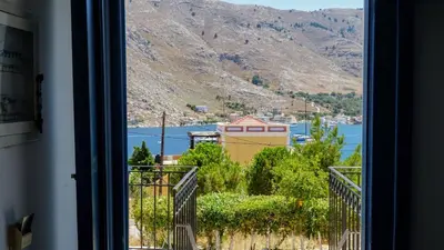 a window with a view of a mountain at Irene Family Apartment in Symi