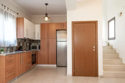 a kitchen with wooden cabinets and a refrigerator at Costa Gennadi Villa in Gennadi