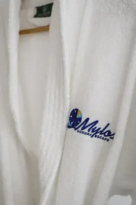 a white sweater with a blue logo on it at Mylos Luxury Escape in Faliraki