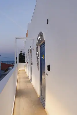 a hallway on the side of a white building with a blue door at Mylos Luxury Escape in Faliraki