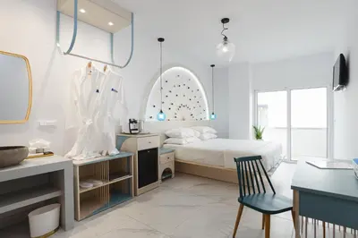 a bedroom with a bed and a desk with a chair at Mylos Luxury Escape in Faliraki