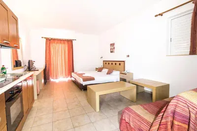 a hotel room with a bed and a kitchen at Lindos Blue Sky in Líndos