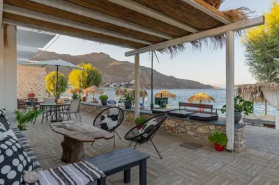 a patio with a table and chairs and the ocean at Uno Beachfront Suite in Livadia