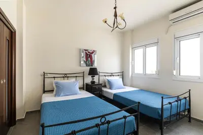 two beds in a room with two windows at ELENA HOUSE 2 in Gennadi