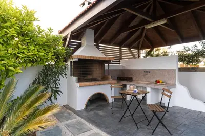 an outdoor kitchen with a grill and a table at ELENA HOUSE 2 in Gennadi