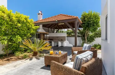 a patio with wicker furniture and an outdoor grill at ELENA HOUSE 2 in Gennadi