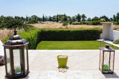 two lanterns on a patio with a garden in the background at Gennadi Villa Del Mar in Gennadi
