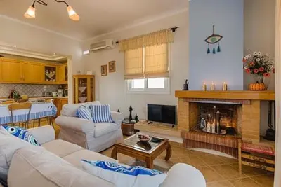 a living room with white furniture and a fireplace at Gennadi Villa Del Mar in Gennadi