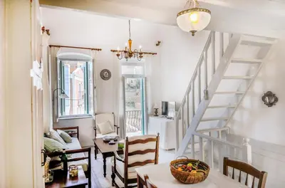 a room with a staircase and a table and chairs at Casa Rinio in Symi