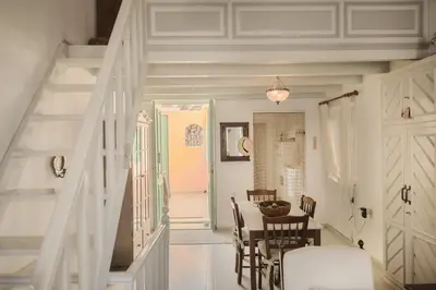 a dining room with a table and a staircase at Casa Rinio in Symi