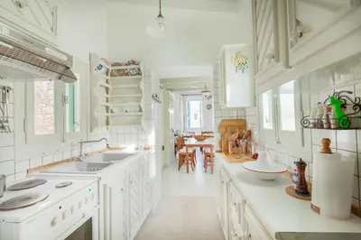 a white kitchen with white cabinets and a sink at Casa Rinio in Symi
