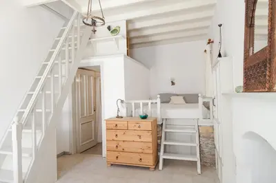 a room with a bunk bed and a wooden dresser at Casa Rinio in Symi
