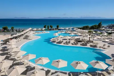 an aerial view of a resort with white umbrellas and the ocean at Belair Beach Hotel in Ixia