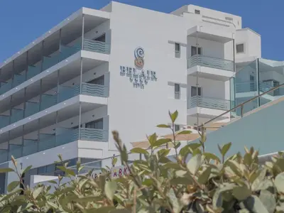 a building with a sign on the side of it at Belair Beach Hotel in Ixia