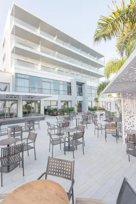 an empty patio with tables and chairs in front of a building at Belair Beach Hotel in Ixia