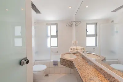 a bathroom with two sinks and a toilet at Belair Beach Hotel in Ixia