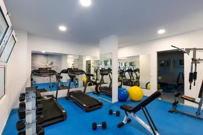 a gym with several treadmills and exercise bikes at Belair Beach Hotel in Ixia